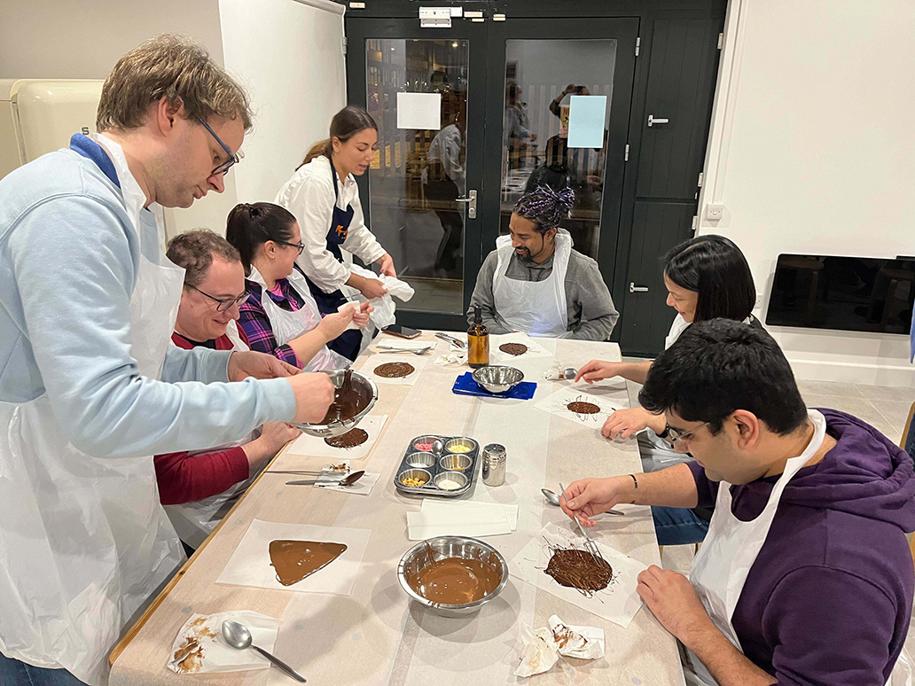 FundApps team around a table baking food. We cook up solutions to deliver the best compliance monitoring and reporting solutions to our clients. 