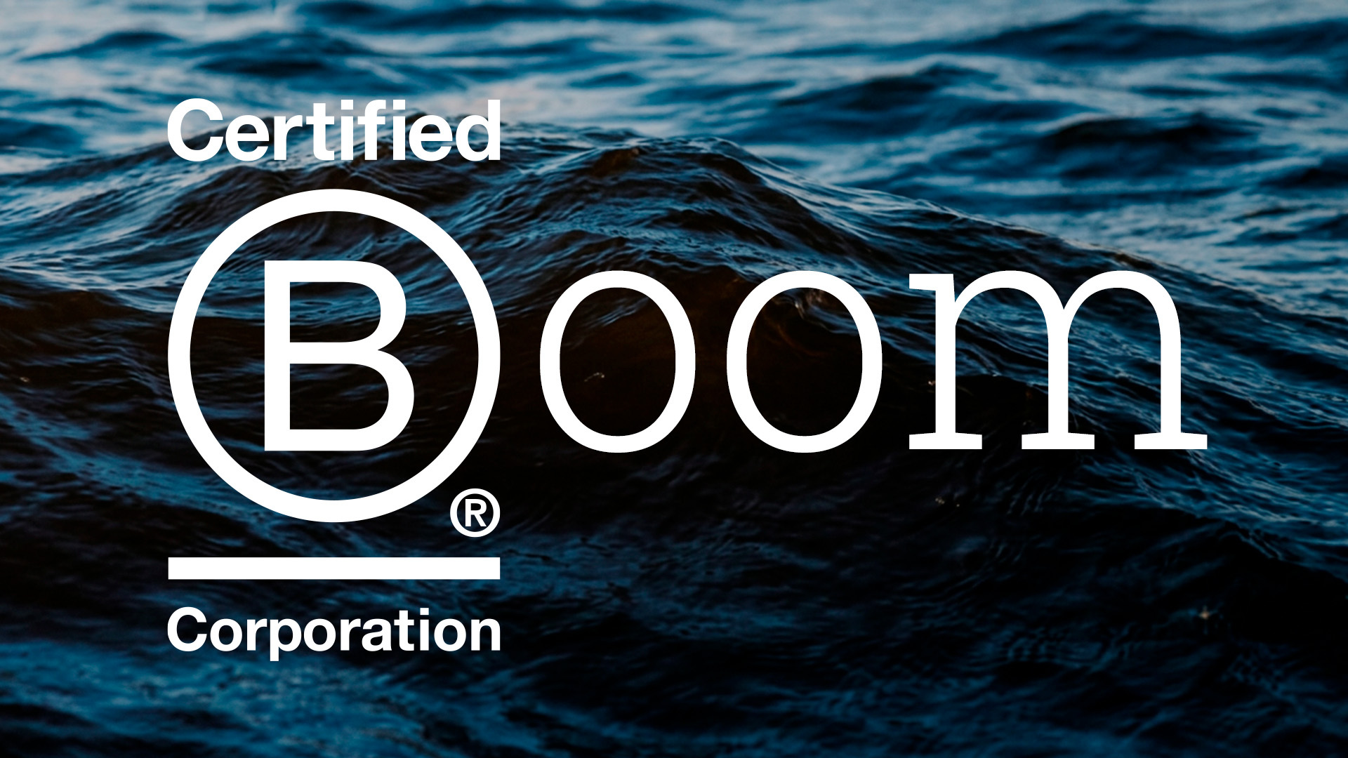 Blue sea behind white B Corp logo next to the word Boom
