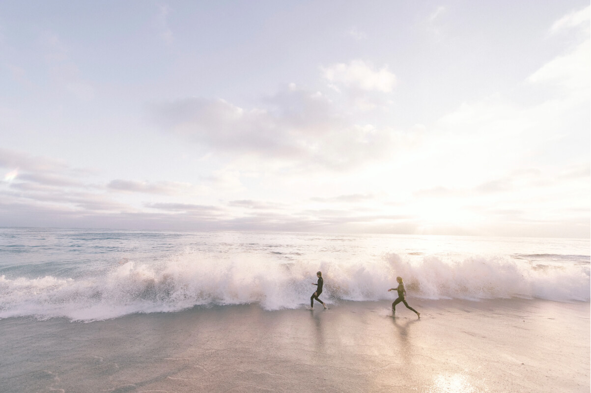 Two surfers running towards a wave coming in at the beach. Take a journey with FundApps and ride the wave with our in-house team and community. 